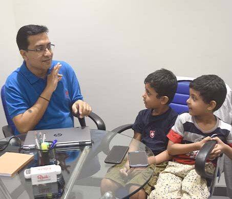 Aqil Chinoy talking with children