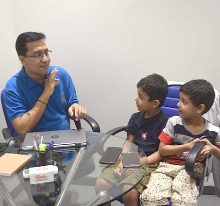 Aqil Chinoy talking with children