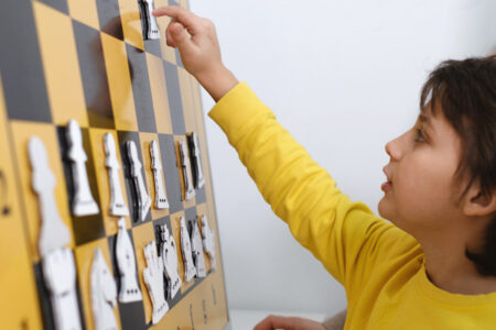 Challenge of boy playing with chess board